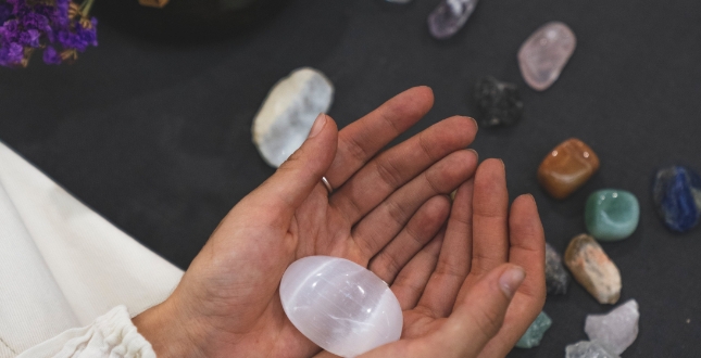 Woman holding in her hands rocks with tarot cards
