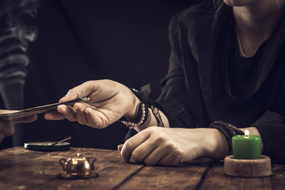 women reading tarot cards with burning candles