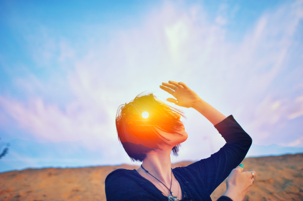  Shaman astrology ritual with a woman praying outdoors, sun rays and fresh air surround her.