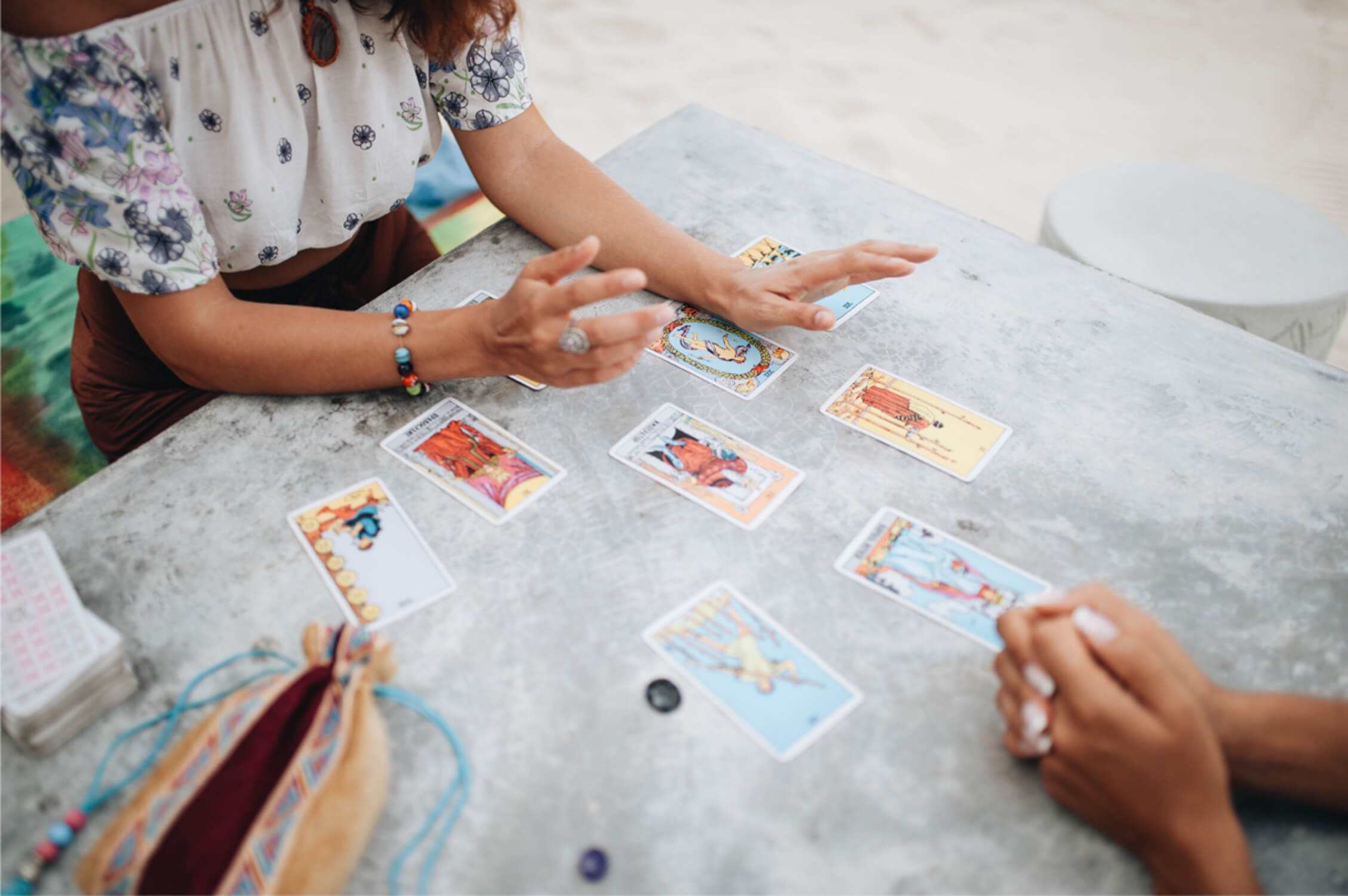 women reading tarot outside on a beach